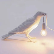 Gray ceramic lively bird resin table lamp featuring a raven holding a glowing bulb for bedroom decorbites lively bird