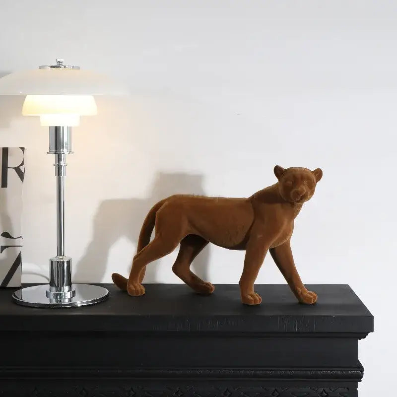 A brown velvet panther figurine with sleek lifelike stance paired with gray concrete leopard flocking sculpture decorbites living room decor