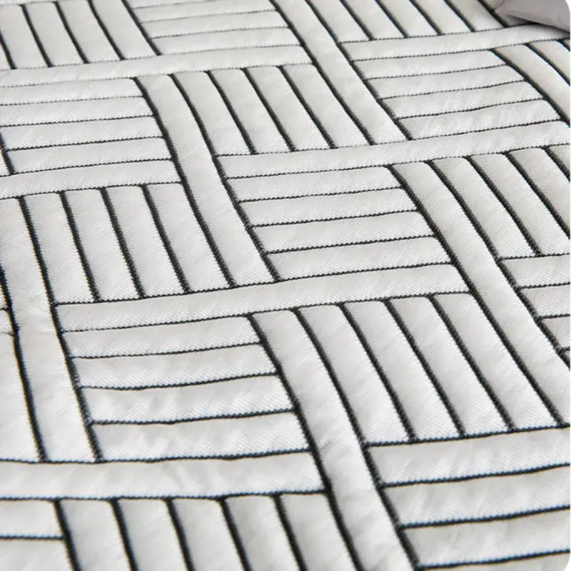 White quilted mattress topper with black geometric stitching on gray cooling ice bean mesh quilted bed mat by decorbites