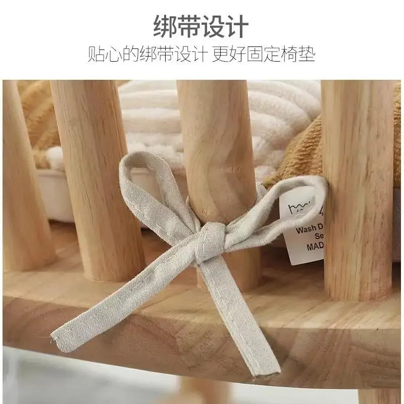 A soft light gray fabric bow tied neatly around a wooden chair leg on a decorbites corduroy cushion dining chair pad