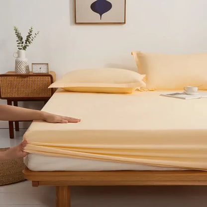 Soft pale yellow decorbites cotton fitted sheet draping neatly over mattress in a gray decorbites cotton fitted sheet set