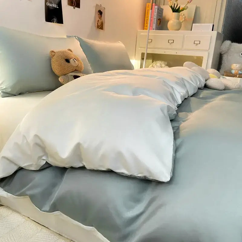 Light blue satin duvet cover set with matching pillowcase and white quilted comforter in double color blocked ice silk bedding set