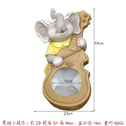 Gray ceramic elephant garden decoration wearing a yellow dress holding a guitar-shaped planter with white flowers