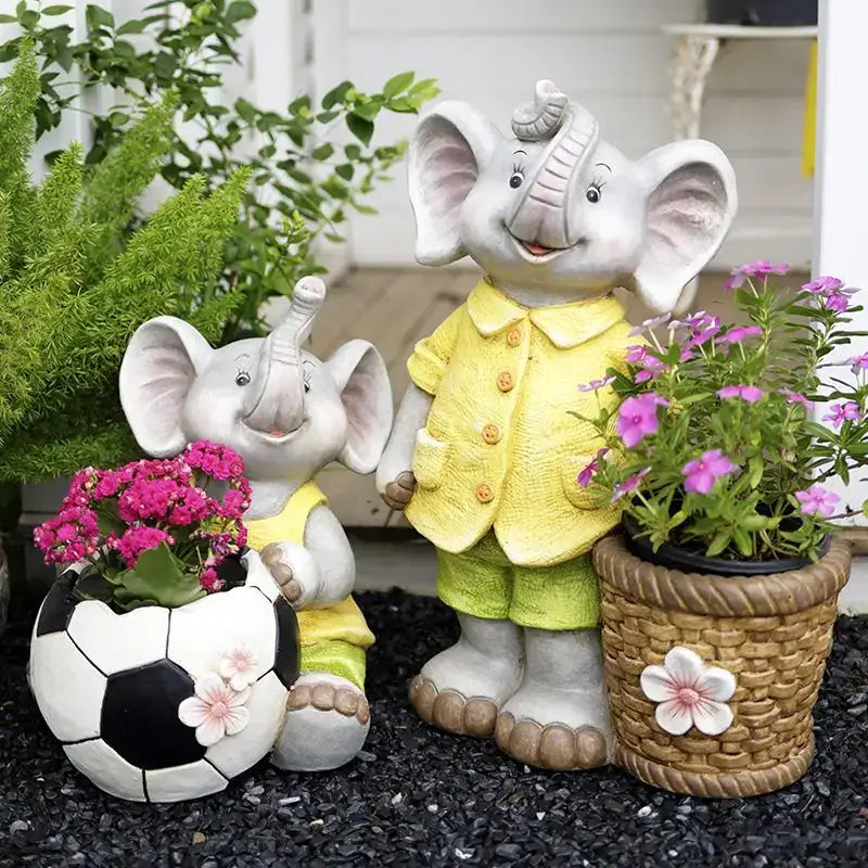 Gray ceramic elephant garden decoration with yellow outfits holding a soccer ball planter and pink flowers basket