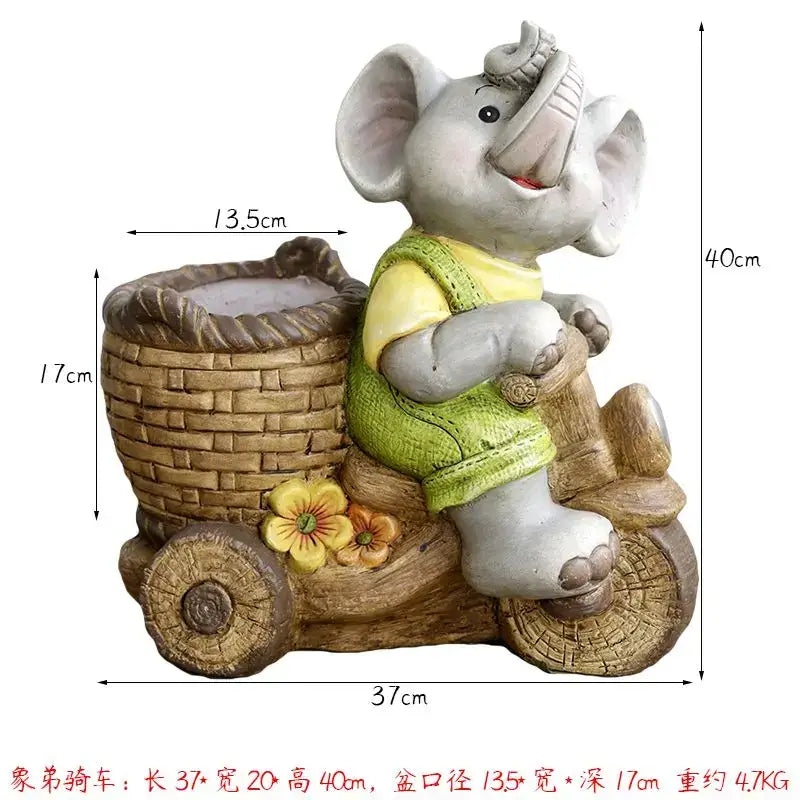 Gray ceramic elephant garden decoration wearing green vest riding wooden cart with woven basket details outdoors