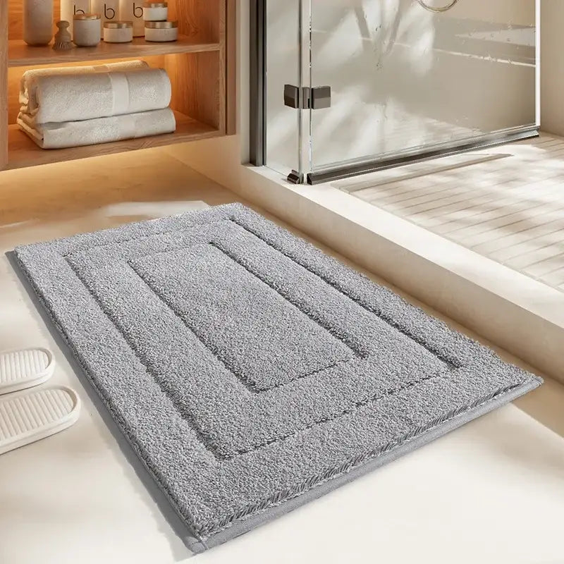 Gray geometric flocked bath mat with plush textured surface and subtle stitched rectangle pattern for bathroom decorbites