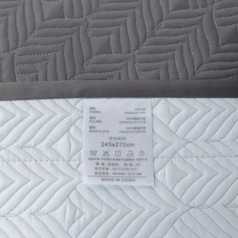 Gray geometric quilted egyptian cotton bedspread set showing mattress cover with fabric composition and size label