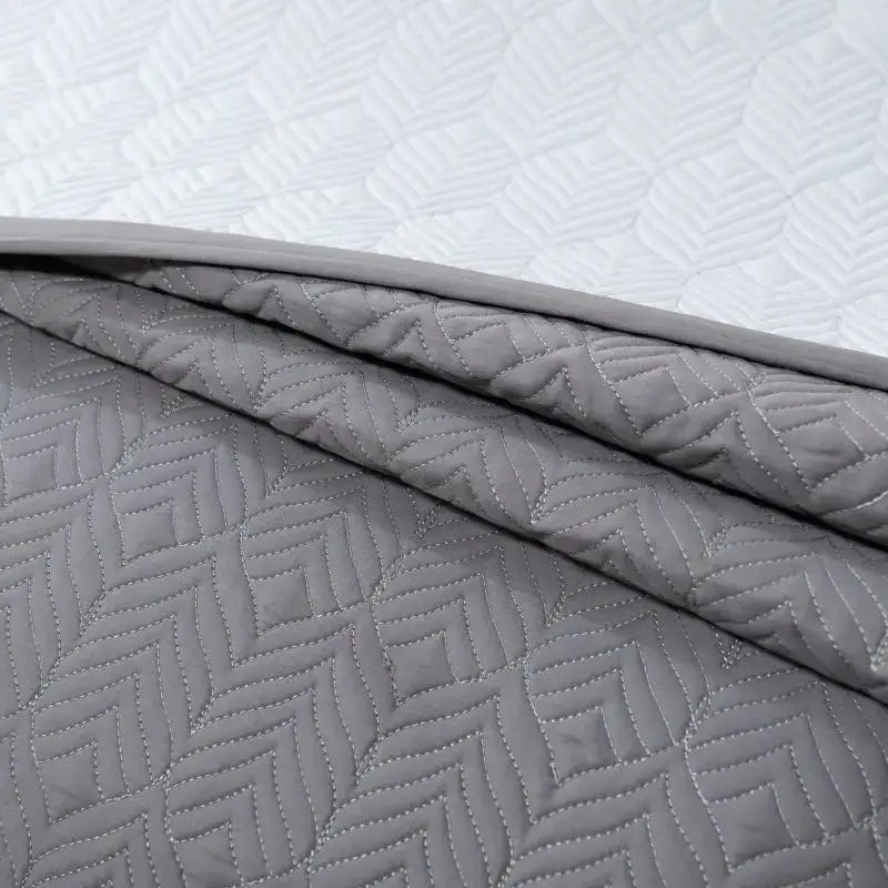 Gray geometric quilted bedspread set made of egyptian cotton featuring white stitching for bedroom use