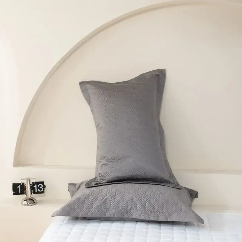 Gray quilted pillow sham with subtle leaf pattern from egyptian cotton bedspread set in geometric design