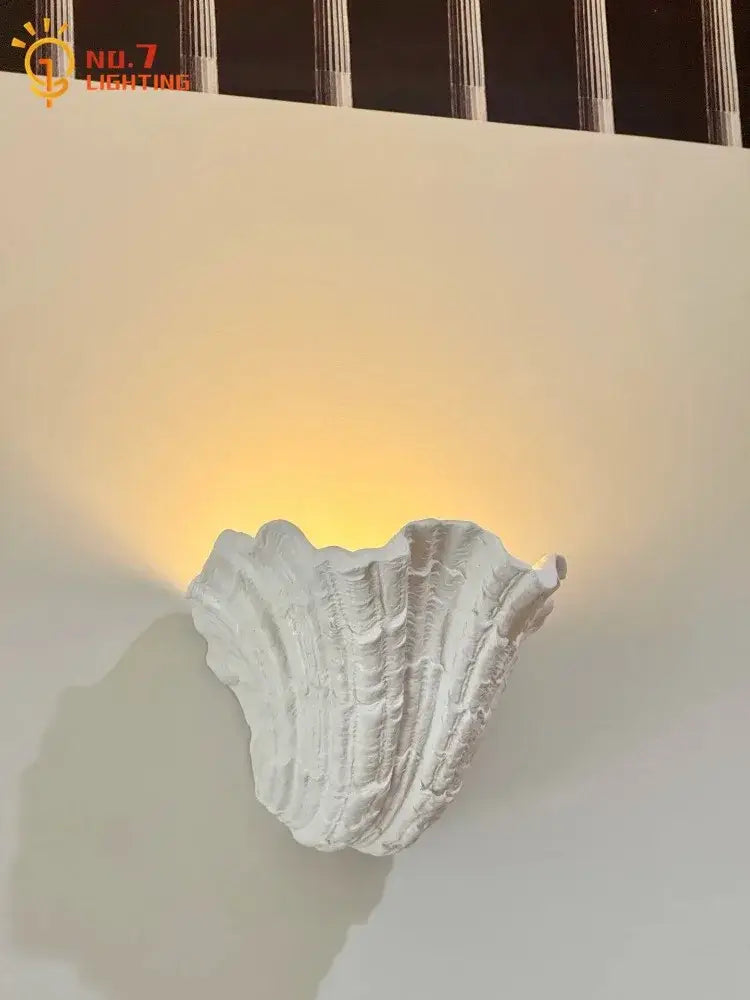 Gray gypsum shell led wall lamp with white textured shell design emitting a warm glow for bedroom use