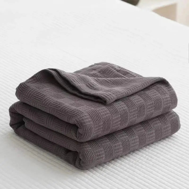 Folded dark gray decorbites cotton waffle towel quilt with textured woven diamond pattern for bedroom or office decor