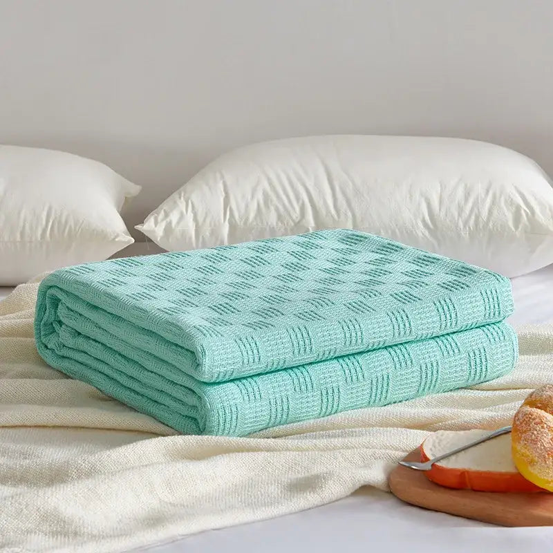 A soft mint green knitted throw blanket with a textured diamond pattern complements the gray herringbone cotton waffle towel quilt for bedroom decorbites cotton waffle