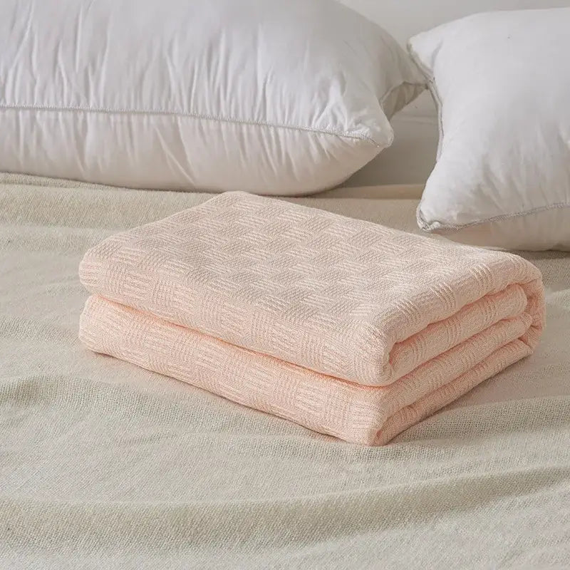A soft pale pink cotton waffle towel quilt with subtle woven texture for bedroom or office decorbites cotton waffle
