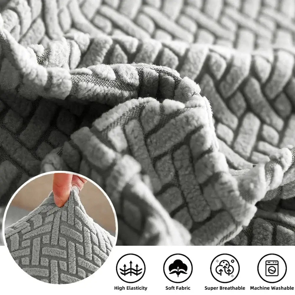 Gray herringbone stretch sofa seat cover with a plush textured woven fabric protecting living room furniture