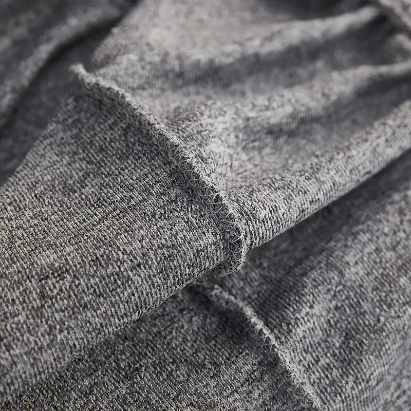 A soft heather gray decorbites jacquard sofa cover with textured weave and frayed edge for living room furniture protection