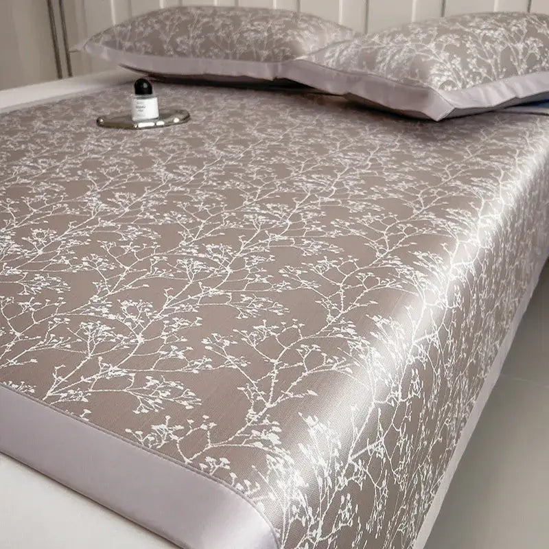 Beige satin bed sheet with delicate white floral embroidery in a gray and lavender branch pattern bed mat set for cooling