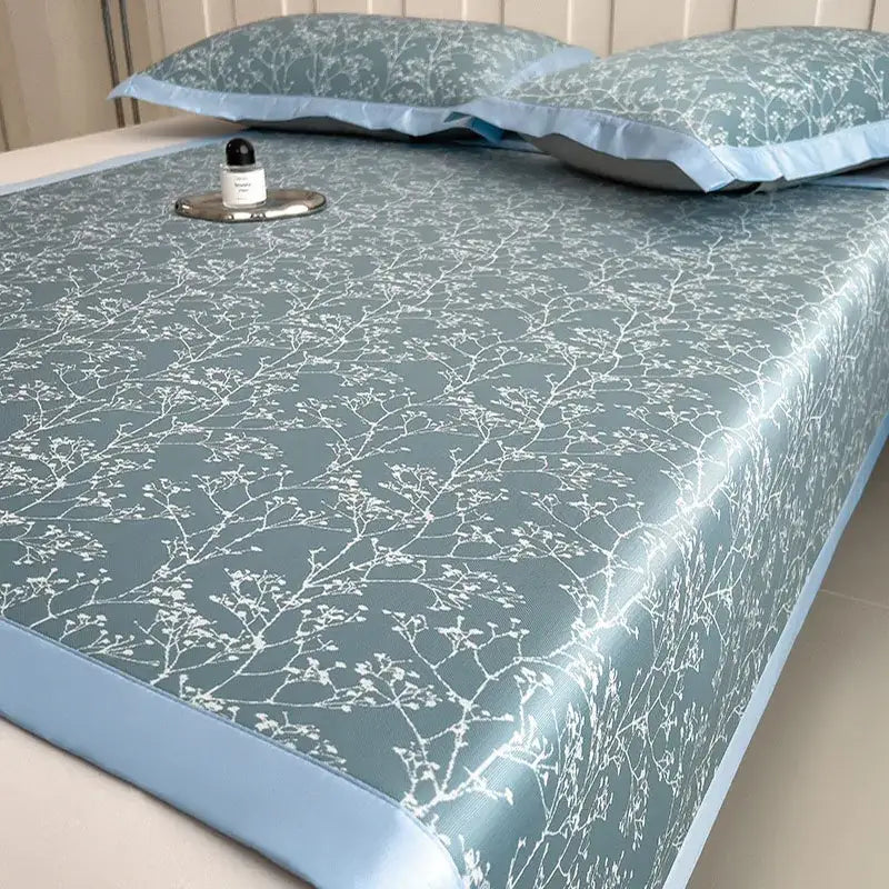 Light blue cooling bed mat set with gray and lavender branch pattern and satin-like edges for bedroom use