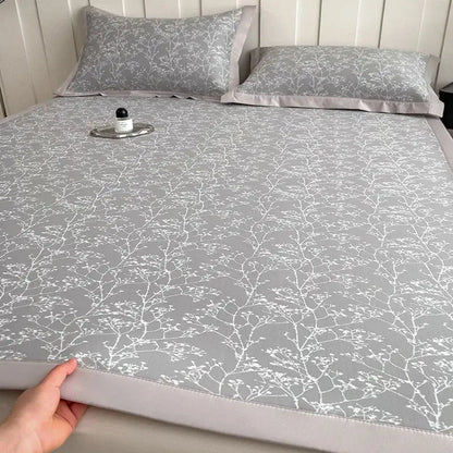 Gray cooling mattress pad with lavender branch pattern and satin border in a bed mat set for bedroom use