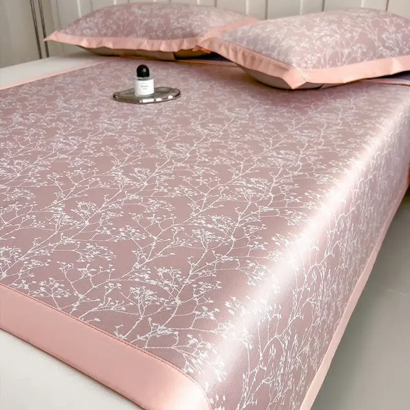 Pink satin-like bed mat with white floral branch pattern from gray and lavender branch pattern bed mat set for cooling use