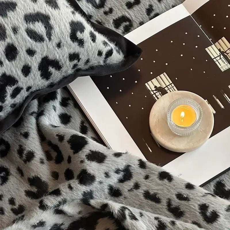A plush gray and black leopard print luxury mink fur blanket with soft texture and fringed edges for decorbites leopard print decor