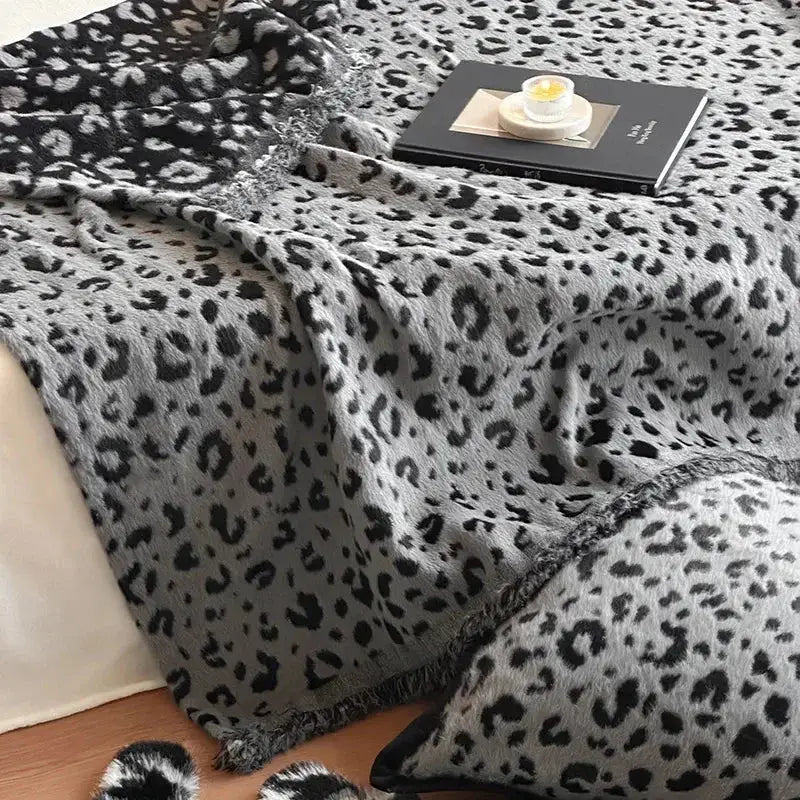 A cozy gray and black leopard print luxury mink fur blanket with soft plush texture and fringed edges for decorbites leopard print