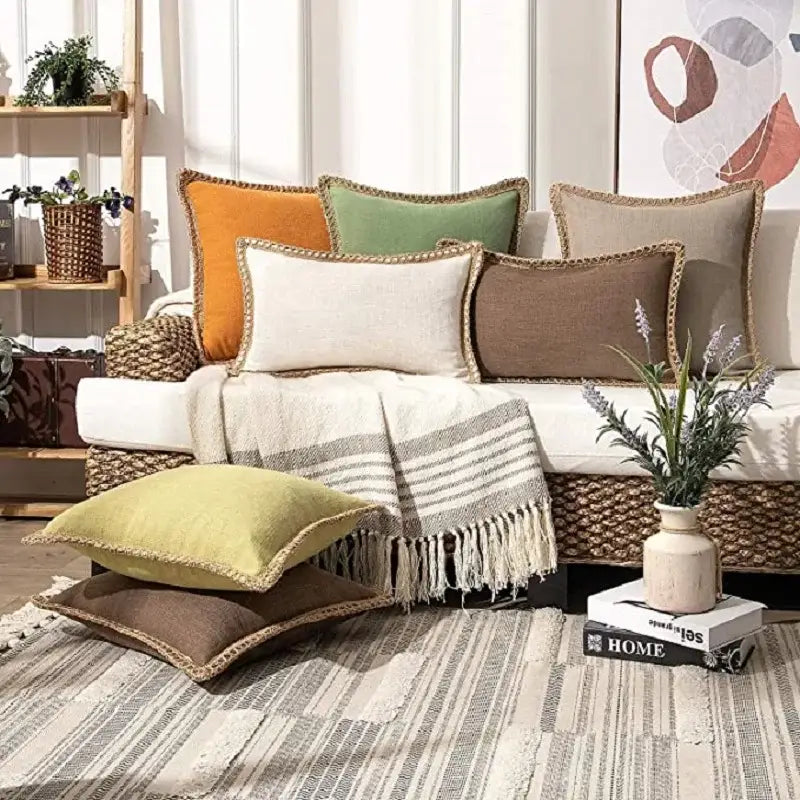 A cozy woven wicker sofa with earth-toned decorbites linen square throw pillow covers for bedroom decor
