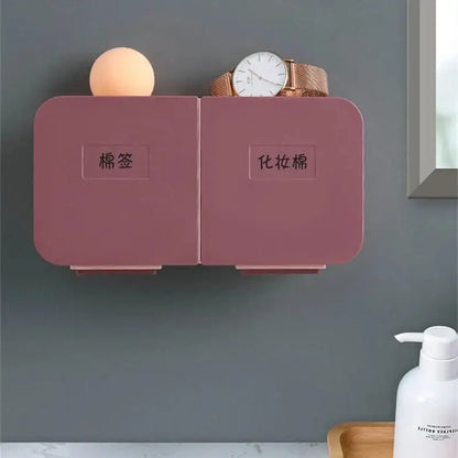 Pink dual-compartment wall-mounted organizer with labeled sections for cotton pads and makeup towels by decorbites cotton swab