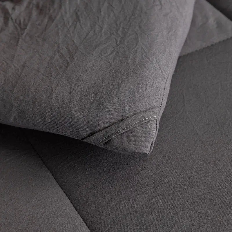 A soft dark gray linen pillow with subtle stitching in the decorbites cozy quilt set for bedroom comfort