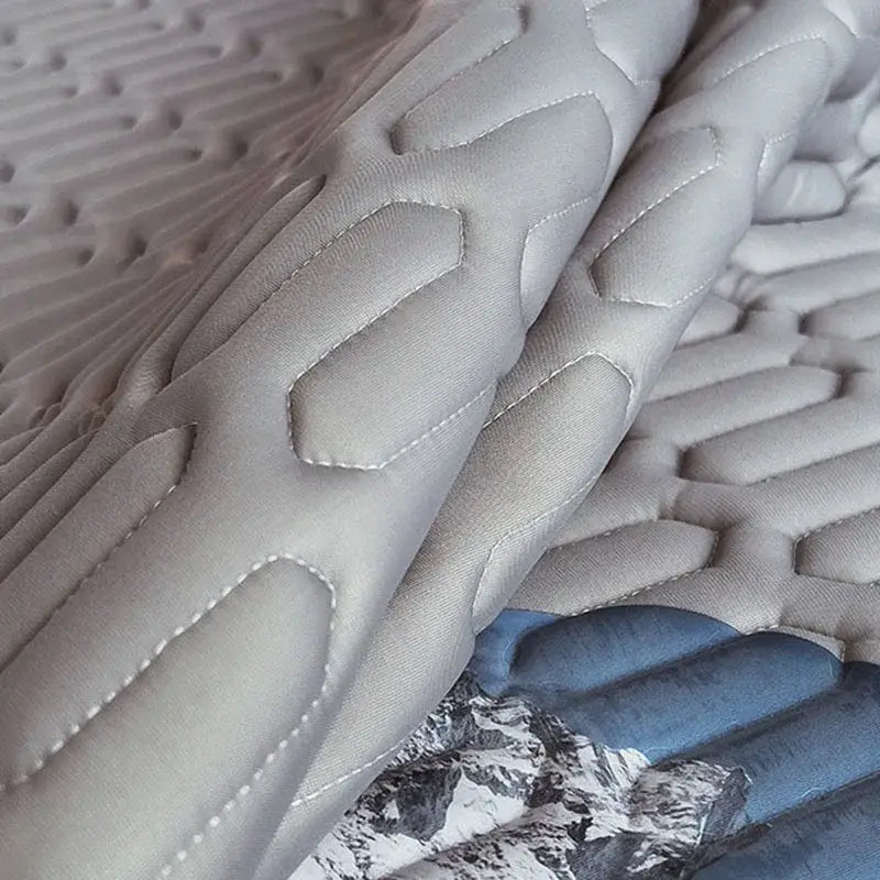 Gray quilted latex bed mat set with textured honeycomb pattern and white stitching for enhanced bedroom mattress comfort