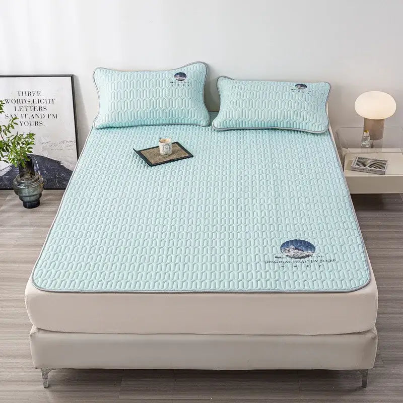Light blue quilted cooling latex bed mat pad with embroidered mountain and text design for bedroom use