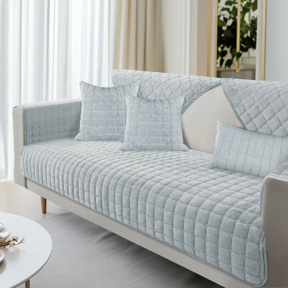 Light blue quilted sofa cover with soft textured fabric and diamond stitching for living room furniture protection