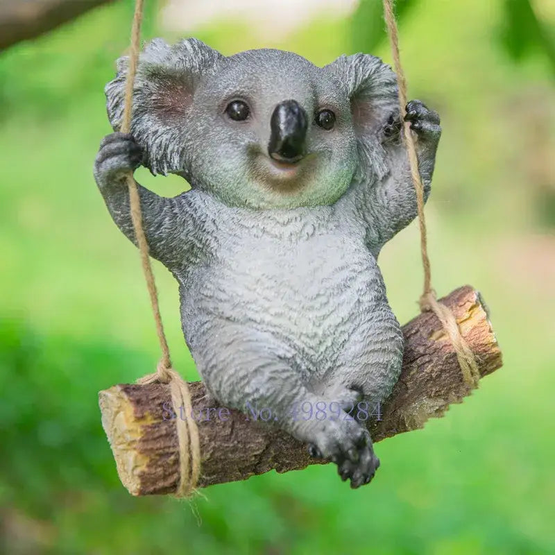 Gray resin cartoon koala hanging from rope on log swing garden sculpture for outdoor decor by decorbites cartoon koala
