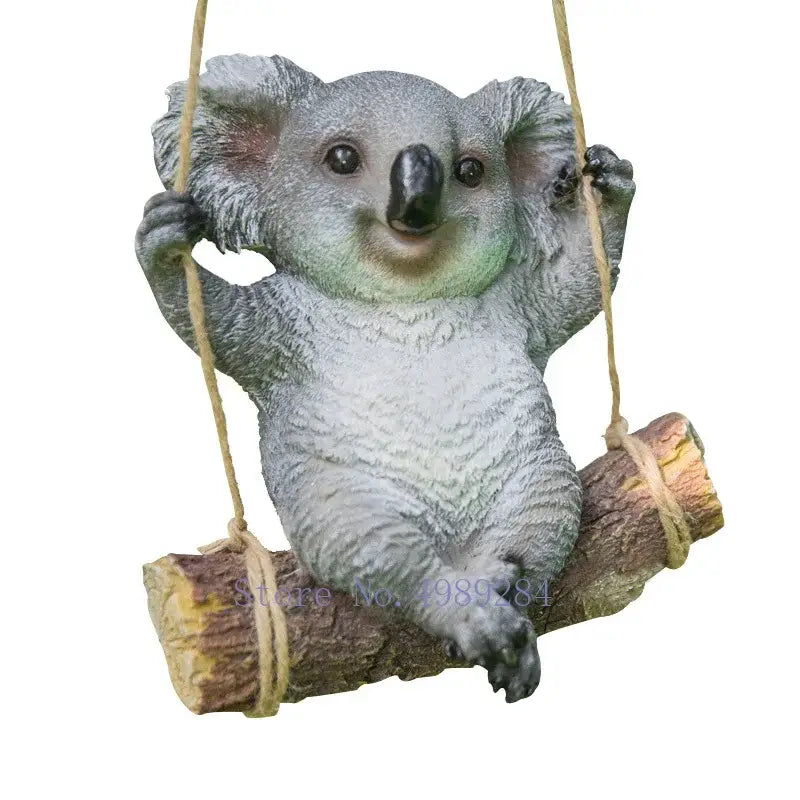 Gray resin cartoon koala garden sculpture with detailed fur hanging from rope swing mounted on rustic wooden log decorbites cartoon koala