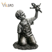 Gray resin super nurse angel boy statue kneeling in overalls holding a doll for living room decor