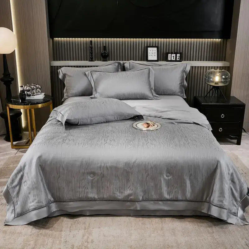 Gray ruched summer quilt set with gray satin-like bedspread featuring subtle textured weave and black trim hem