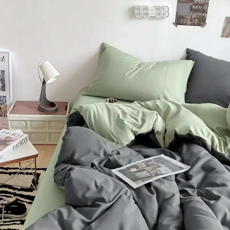 A cozy bed with a gray satin cotton quilted duvet cover in sage green and charcoal gray decorbites cotton quilted set