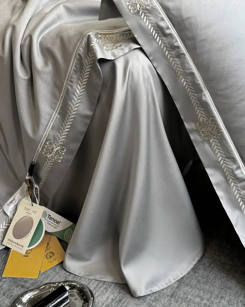 Silver-gray satin bed skirt with delicate gold-thread embroidery complements gray satin eucalyptus fiber summer quilt bedding set by decorbites