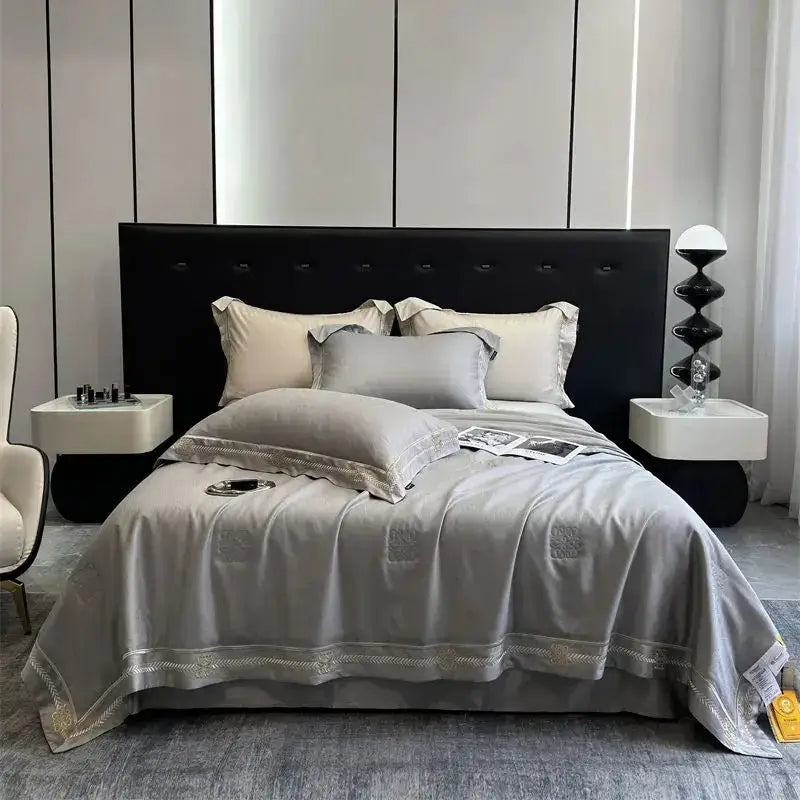 Gray satin eucalyptus fiber summer quilt bedding set with delicate gold embroidery and subtle patterned motifs