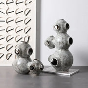 Gray speckled ceramic abstract planet ornament with rounded segmented forms and circular openings for decorbites abstract planet decor
