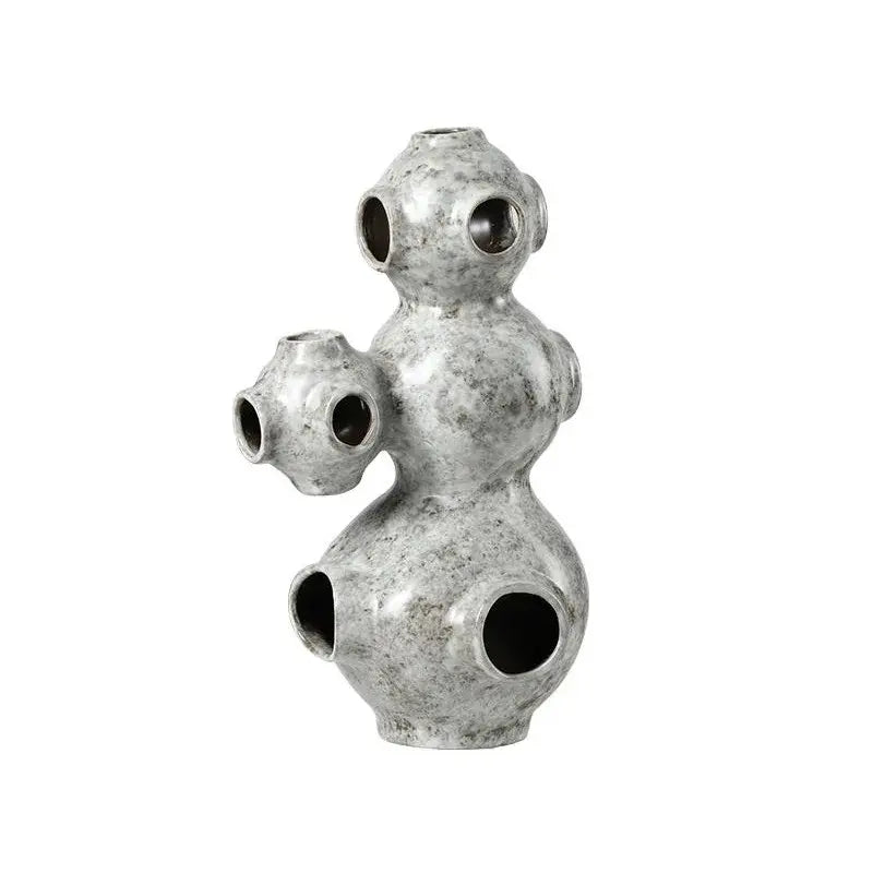 Gray speckled ceramic ornament with three interconnected bulbous sections and circular openings for abstract planet decorbites abstract planet