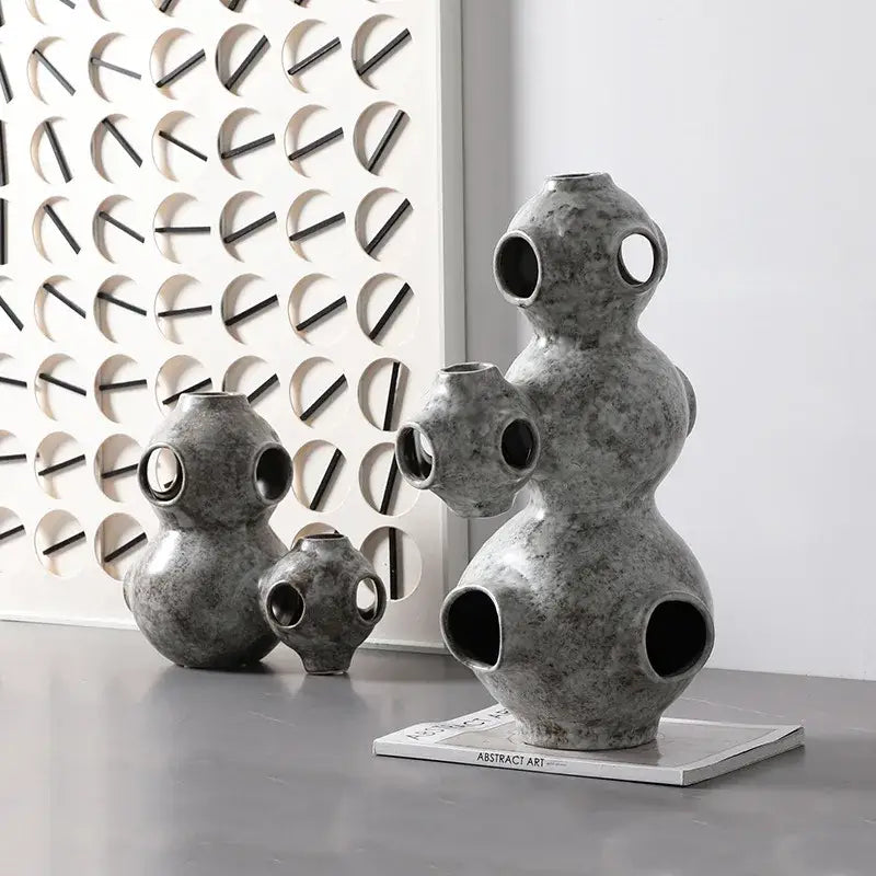 Gray speckled ceramic ornament with textured circular openings and stacked organic form decorbites abstract planet decor