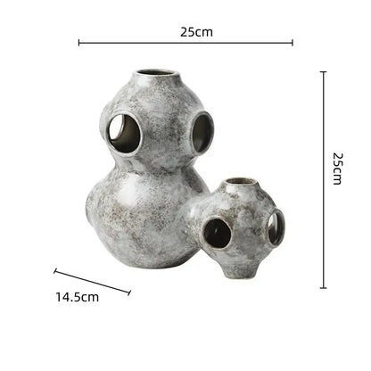 Gray speckled ceramic ornament with three interconnected spherical sections featuring circular openings decorbites abstract planet