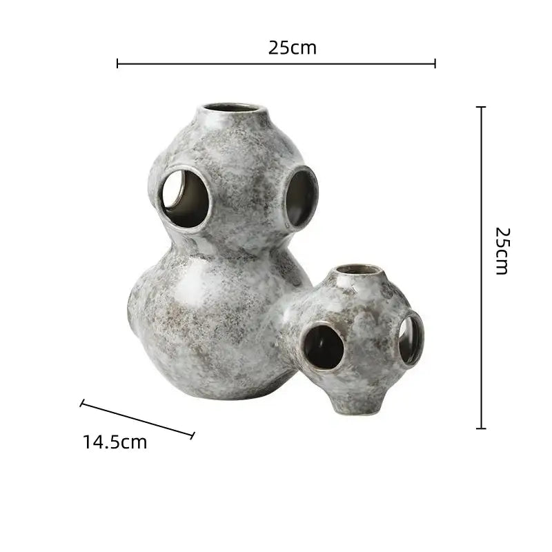 Gray speckled ceramic ornament with three interconnected spherical sections featuring circular openings decorbites abstract planet