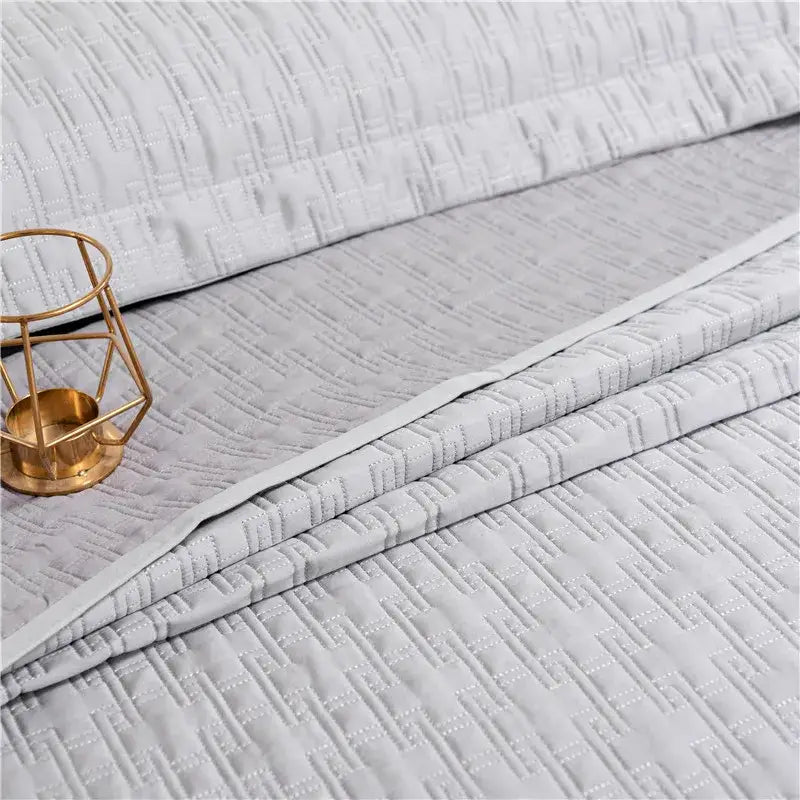 Light gray quilted egyptian cotton quilt set with subtle geometric pattern and soft textured fabric reversible bedspread