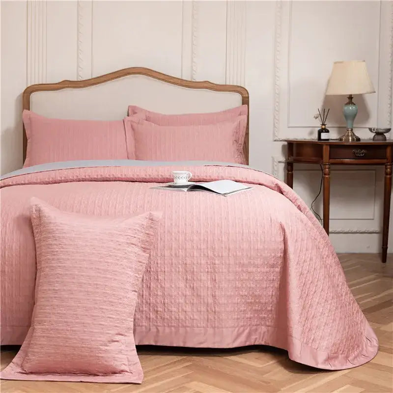 Pink textured egyptian cotton quilt set with matching pillows and subtle gray accent band reversible bedspread