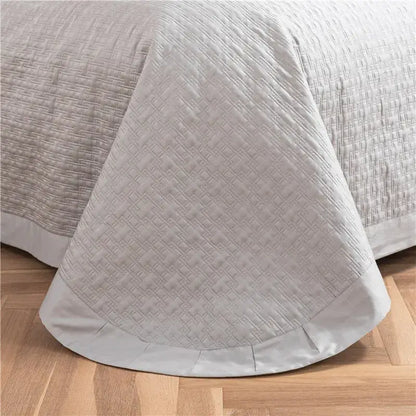 Gray textured egyptian cotton quilt set featuring a soft light gray quilted bedspread with geometric pattern and satin hem