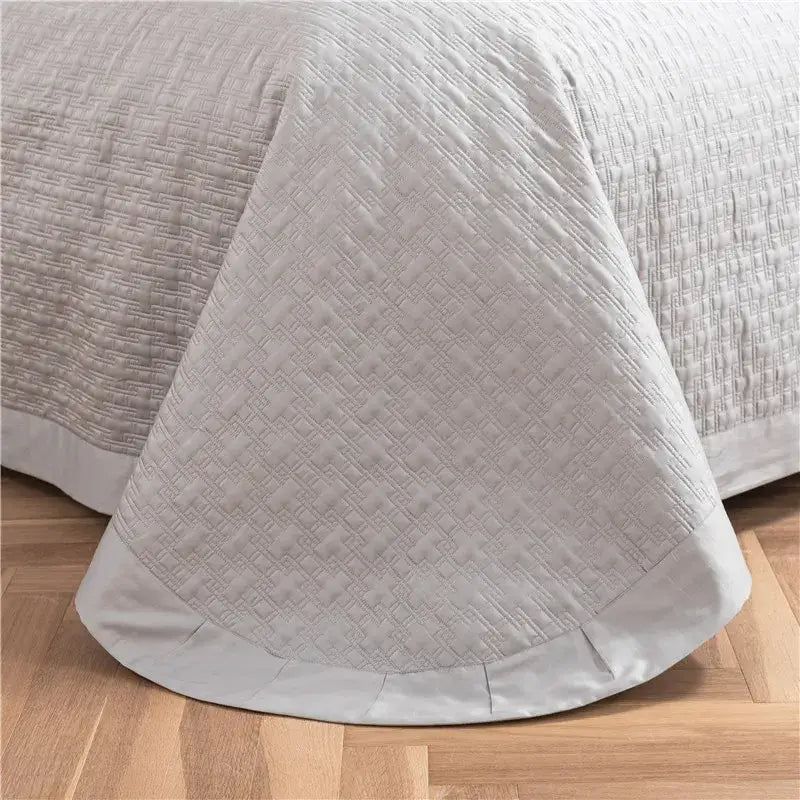 Gray textured egyptian cotton quilt set featuring a soft light gray quilted bedspread with geometric pattern and satin hem