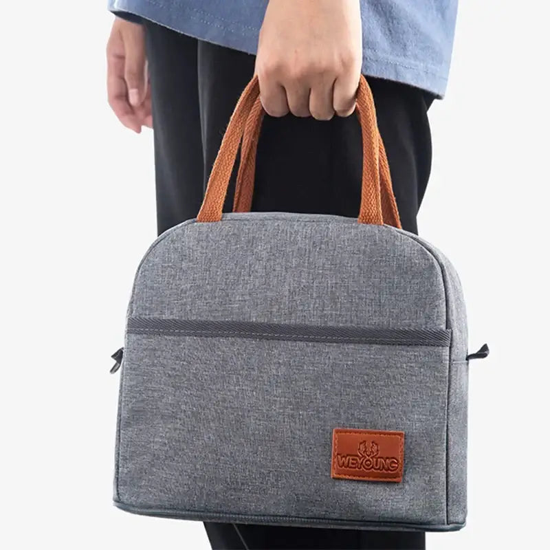 Gray textured insulated lunch bag with orange woven handles and brown leather weyoung brand patch for kitchen use