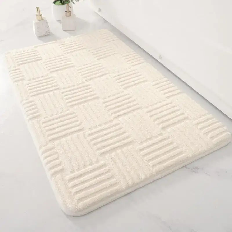 Cream-colored plush floor mat with textured checkered pattern for bathroom use in a soft non slip design