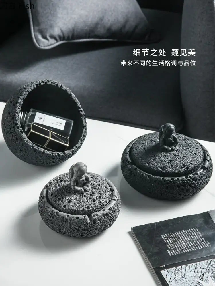 Gray volcanic stone cement astronaut ashtray featuring black lava rock texture and a miniature astronaut figurine for living room use